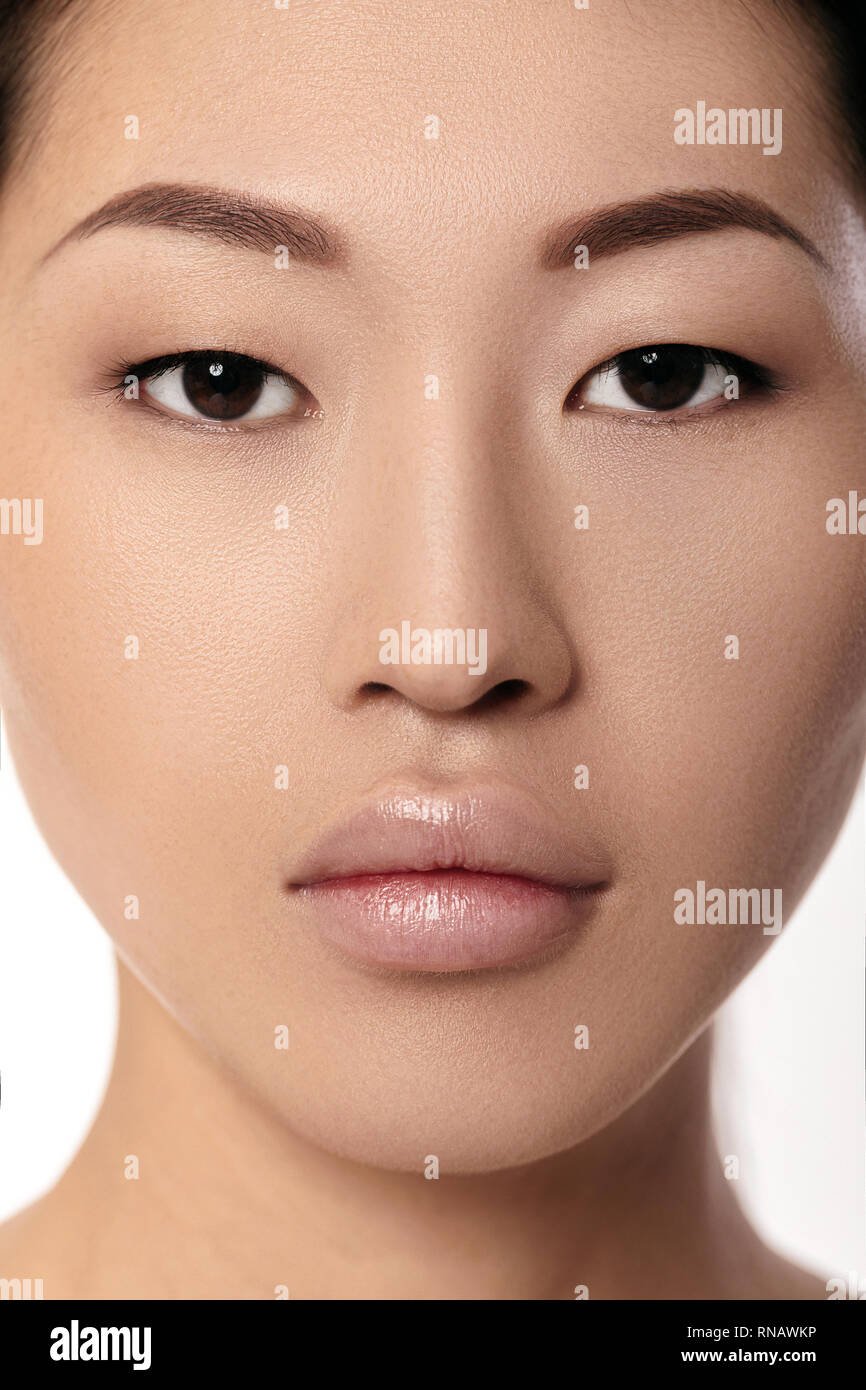 Close-up ritratto di giovane e bella donna asiatica su sfondo bianco closeup. ragazza con la pelle pulita. Labbra femmina dopo la procedura di aumento di spessore Foto Stock