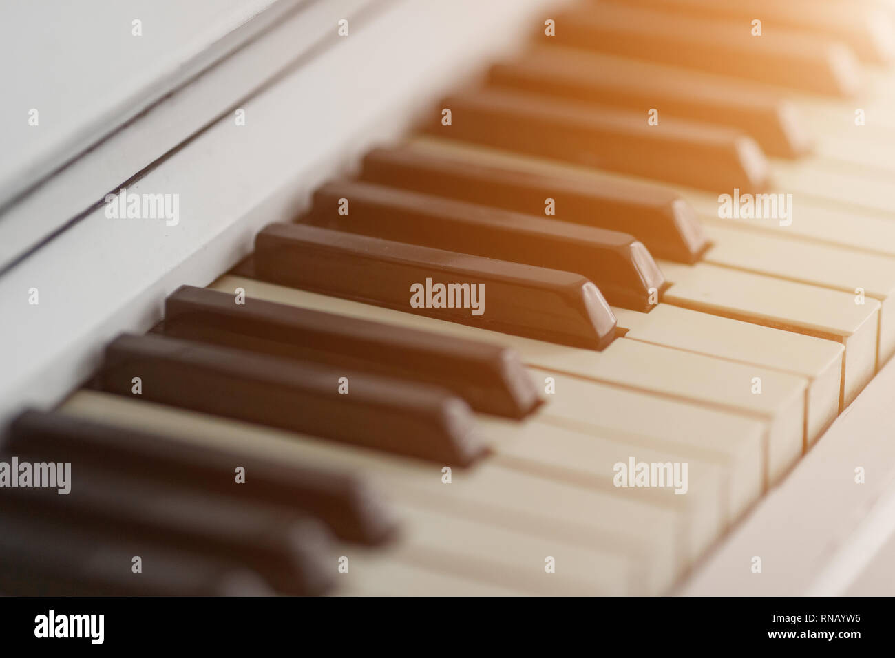 Tastiera di pianoforte closeup con la luce del sole. La musica e il concetto di hobby Foto Stock