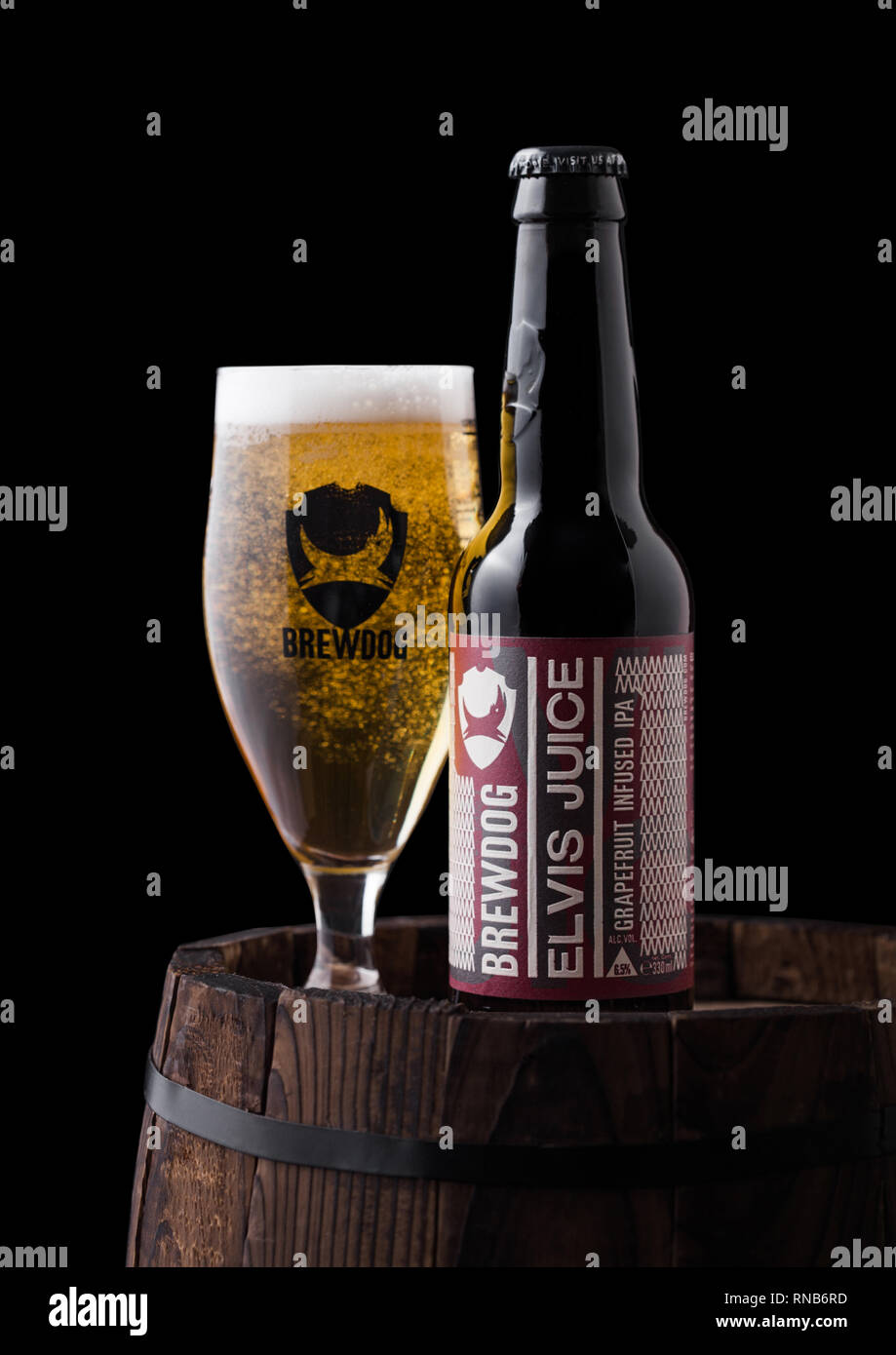 LONDON, Regno Unito - 06 febbraio 2019: bottiglia e bicchiere di Elvis Succhi di pompelmo IPA birra, dal birrificio Brewdog sul vecchio Barile di legno su sfondo nero Foto Stock