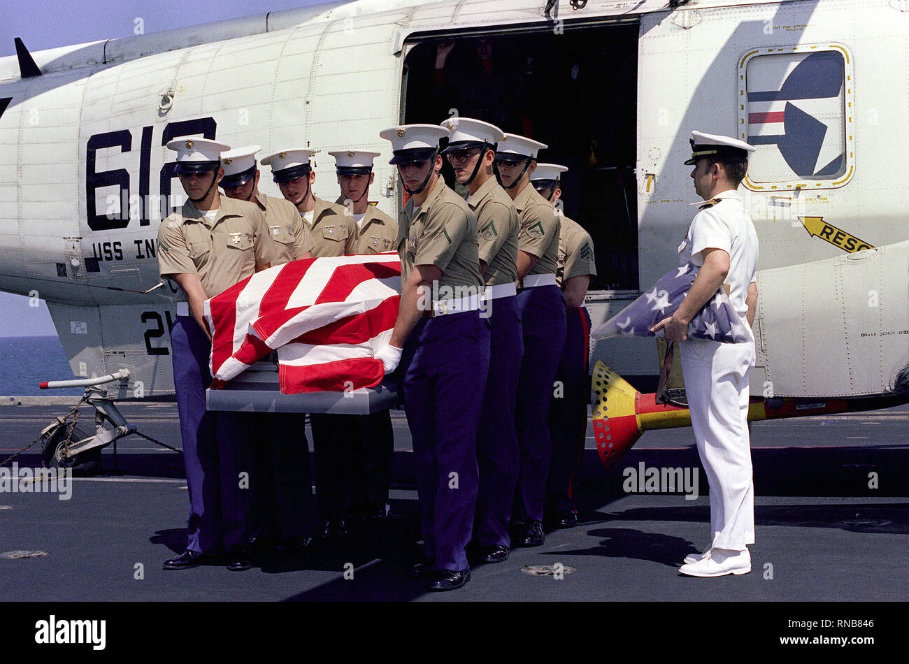 1982 - STATI UNITI Marines a bordo della portaerei USS INDIPENDENZA (CV-62) offload i resti di un comandante di una SH-3 Sea King helciopter, attaccato al Carrier aria Wing 6 (CVW-6). Foto Stock