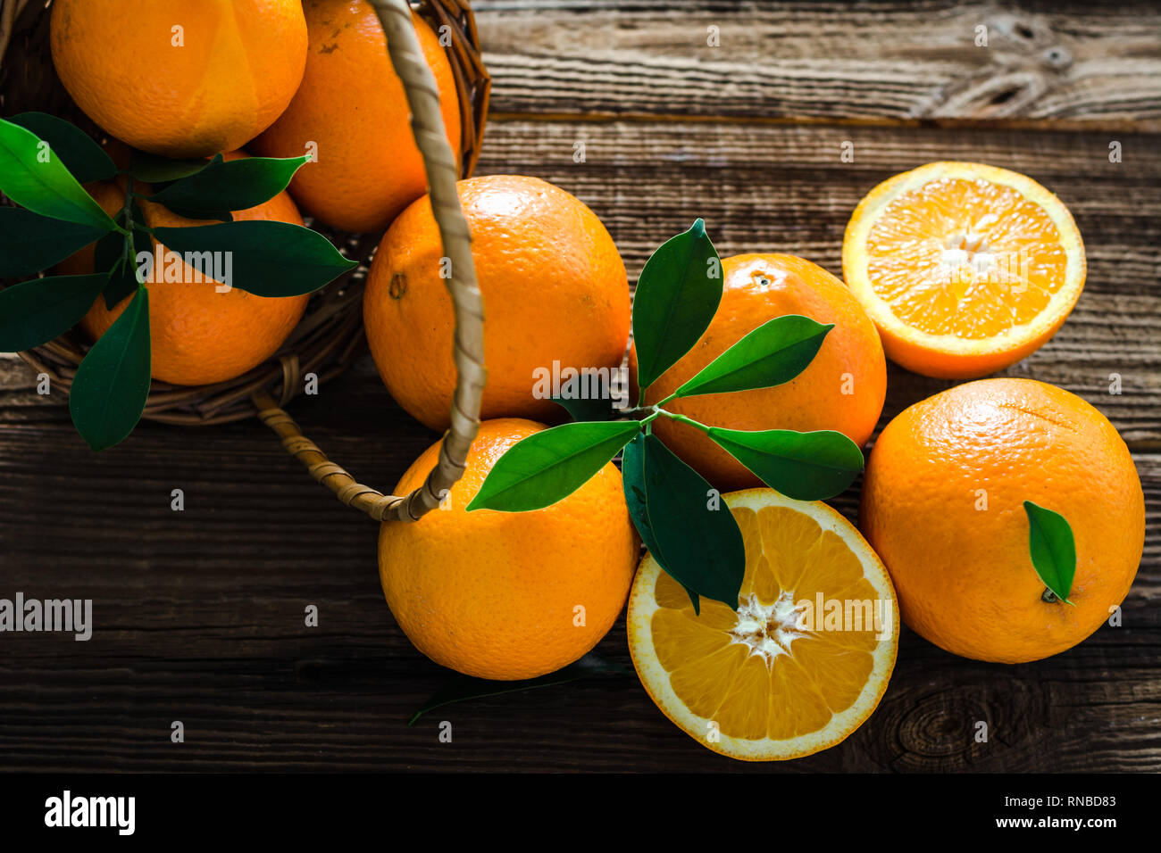 Fresche arance organico in un cesto su un tavolo di legno. Frutta di arancia sul mercato. Foto Stock