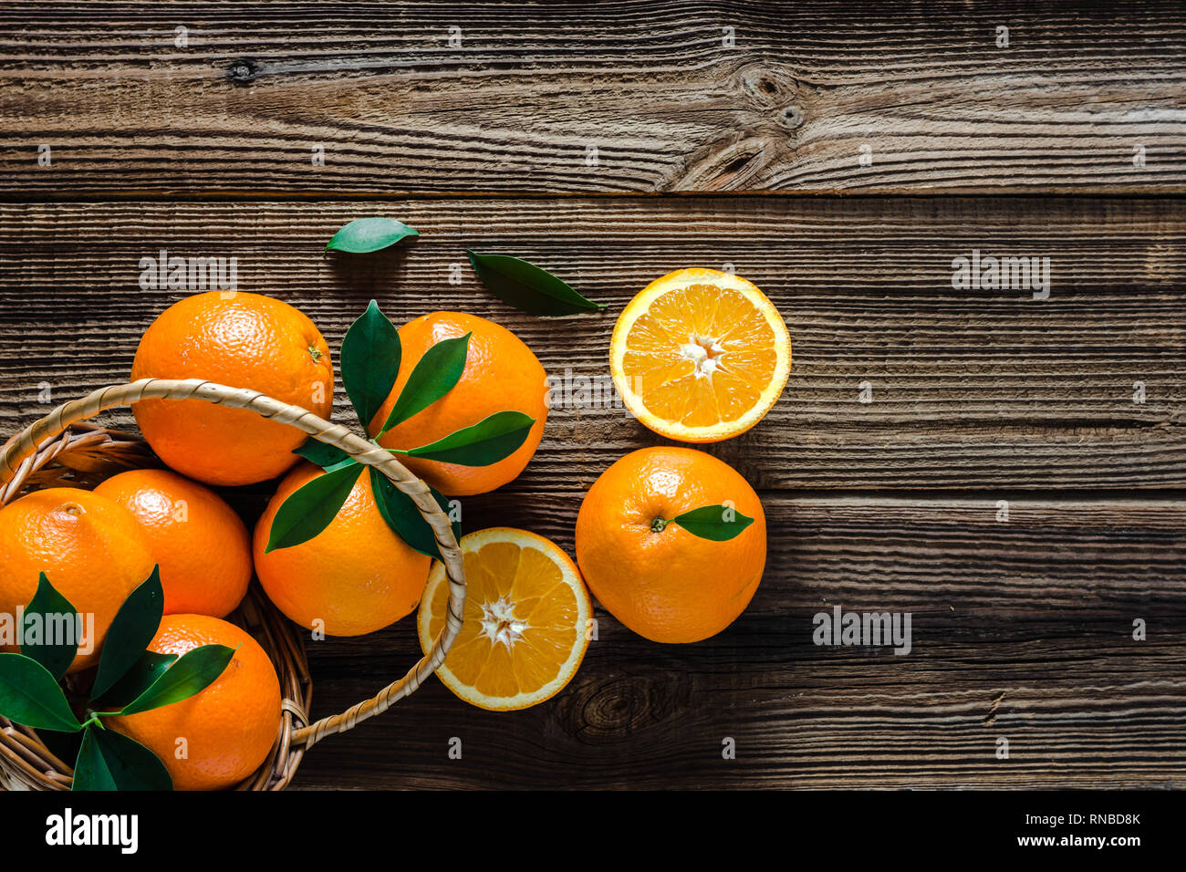Cestello con arance su sfondo di legno. Fattoria fresco arancione sul mercato. Foto Stock