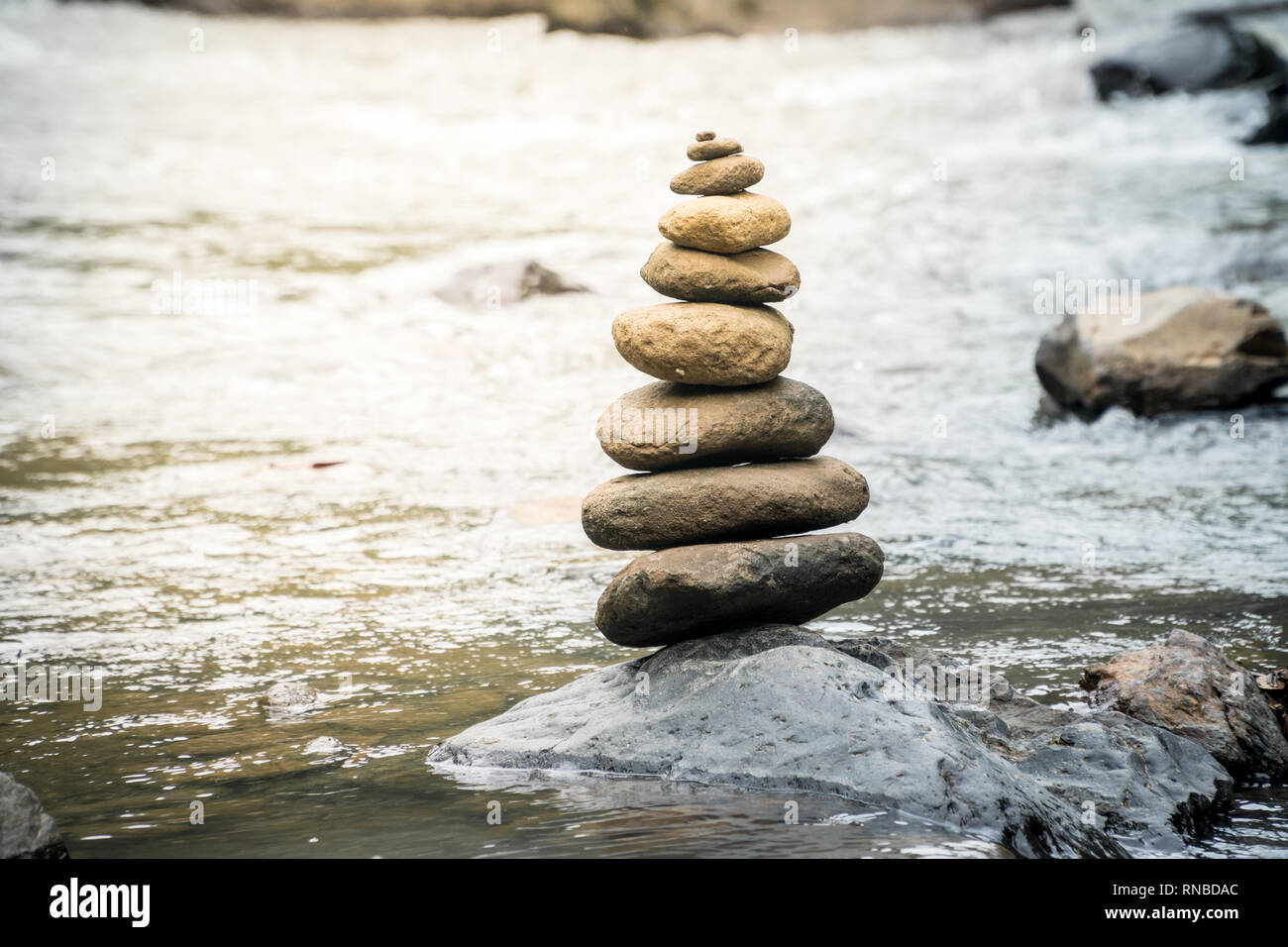 Pietre di bilanciamento su una roccia di fiume. Il concetto di stabilità in un mondo di turbolenza Foto Stock