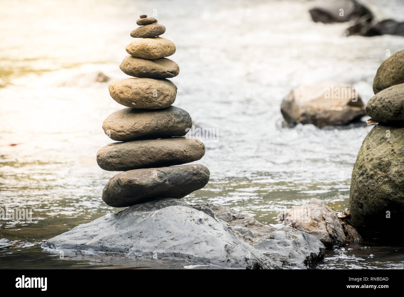 Pietre di bilanciamento su una roccia di fiume. Il concetto di stabilità in un mondo di turbolenza Foto Stock