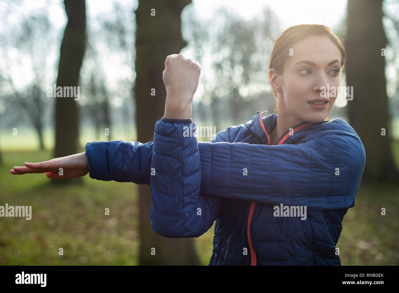 Donna in fase di riscaldamento per la ginnastica mattutina con tratti in Winter Park Foto Stock