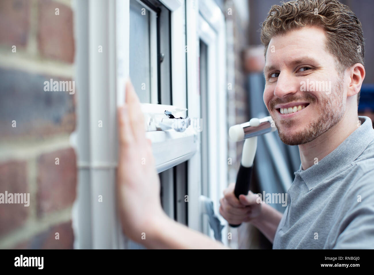 Ritratto di lavoratore edile Installazione di nuove finestre in casa Foto Stock