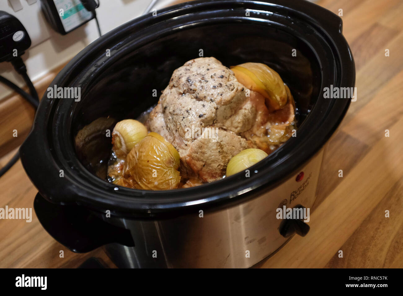 La cottura di un misto di carne di maiale in una Russel Hobbs slow cooker Foto Stock