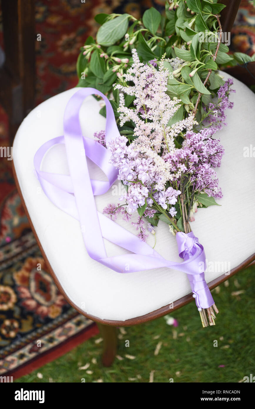 Un bellissimo tavolo esterno display, con un sacco di fiori di primavera in vari colori- situato in un verde giardino erboso su un luminoso giorno Foto Stock