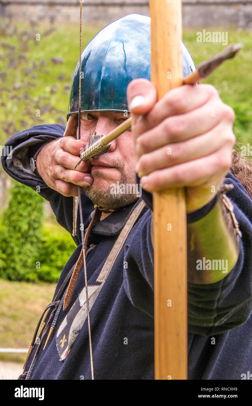 Un arciere in abito medievale siti lungo il suo arco durante una rievocazione storica da Raven Tour Storia Vivente Gruppo Arundel Castle ©Julia Claxton Foto Stock