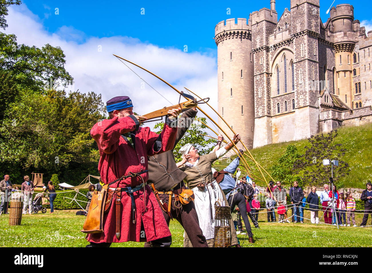 Arcieri in abito medievale durante una rievocazione storica da Raven Tour Storia Vivente gruppo nella parte anteriore del Castello di Arundel Foto ©Julia Claxton Foto Stock