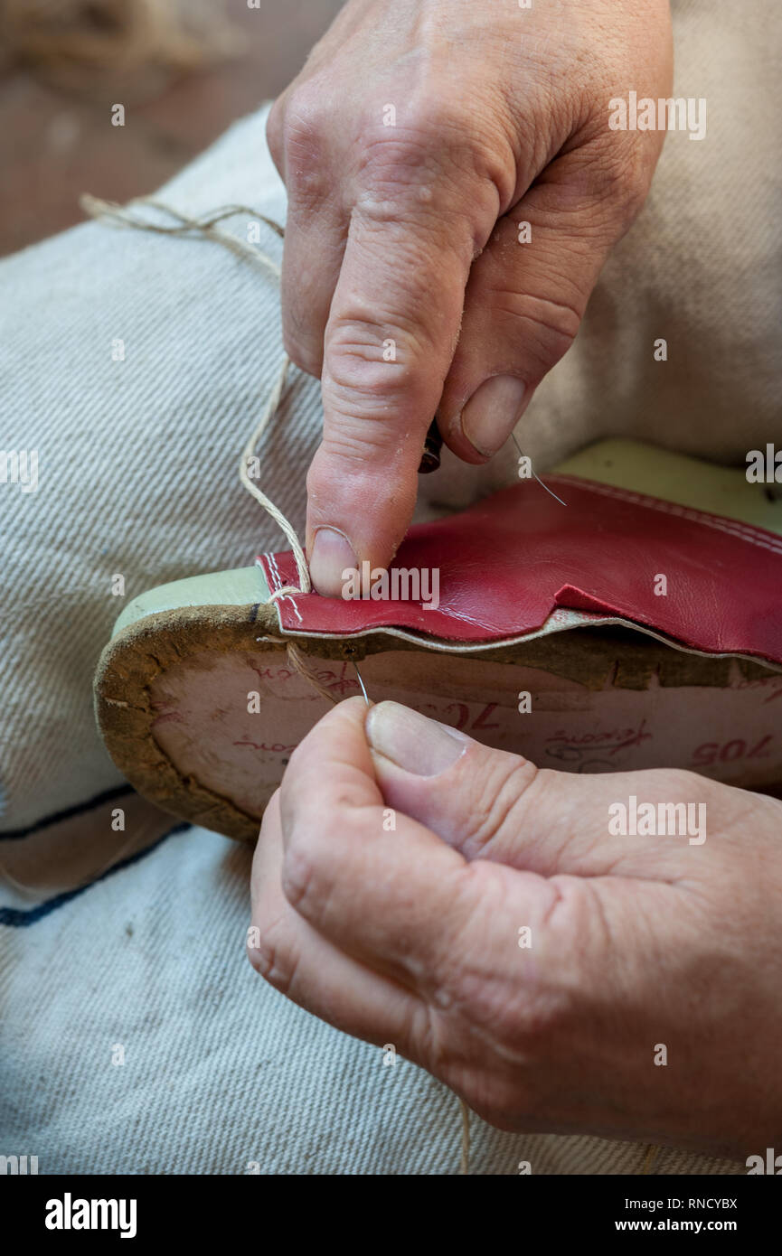 Il calzolaio cuce una calzatura craftily, con lo spago e awl Foto Stock