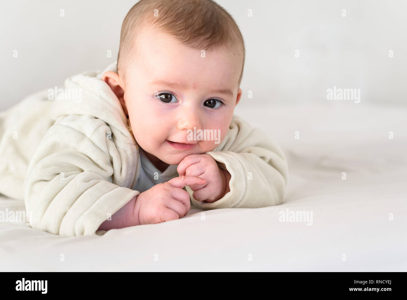 Ritratto di un adorabile sorridente bambino tiene testa in alto, vestito in pigiama. Foto Stock