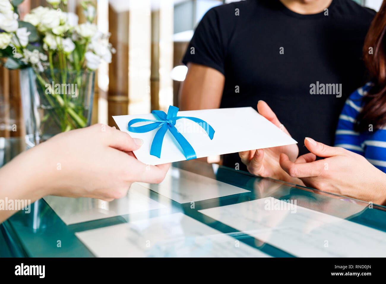 Receptionist donna dà il certificato di visita della spa salone. Foto Stock