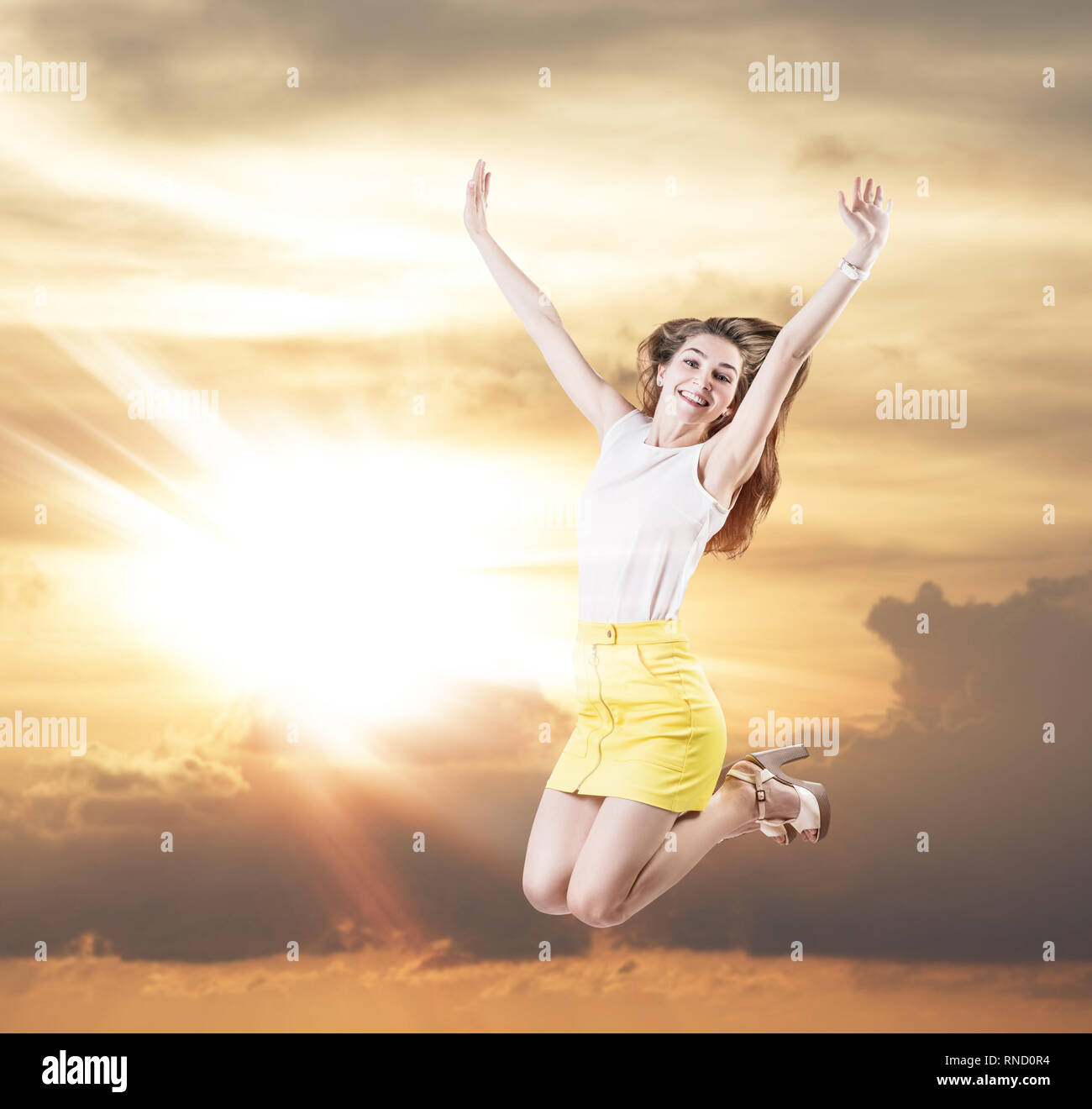 Giovane donna salta nel cielo nuvoloso. Foto Stock