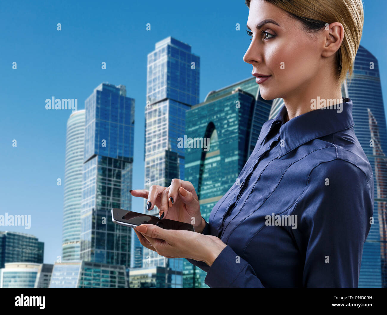 Business donna con lo smartphone sta oltre il paesaggio sullo sfondo. Foto Stock