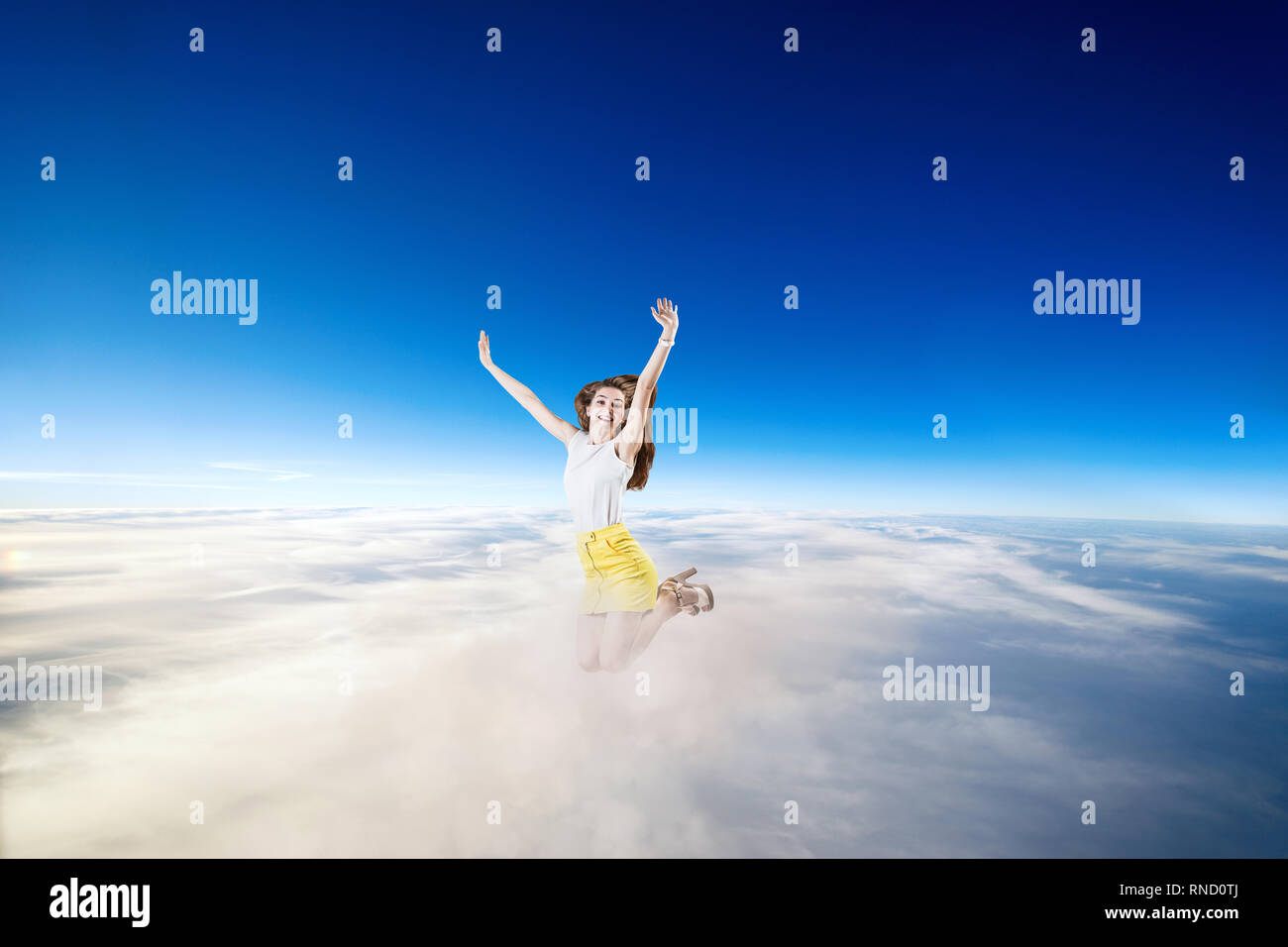 Giovane donna salti nel blu cielo nuvoloso. Foto Stock