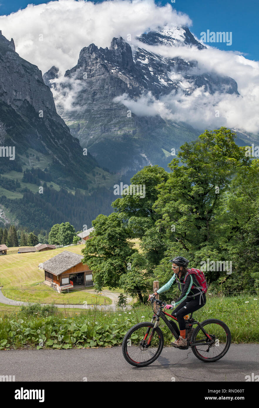 Bella e sempre giovane donna Senior in sella il suo e-mountainbike al di sotto dell'Eiger northface, Jungfrauregion, Foto Stock