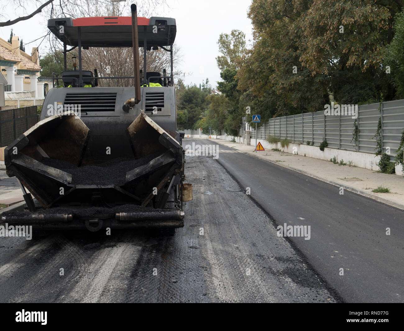 Asfalto macchina che le pile e preme asfalto caldo. Riparazione su strada della macchina. Riparare nella città moderna. Foto Stock