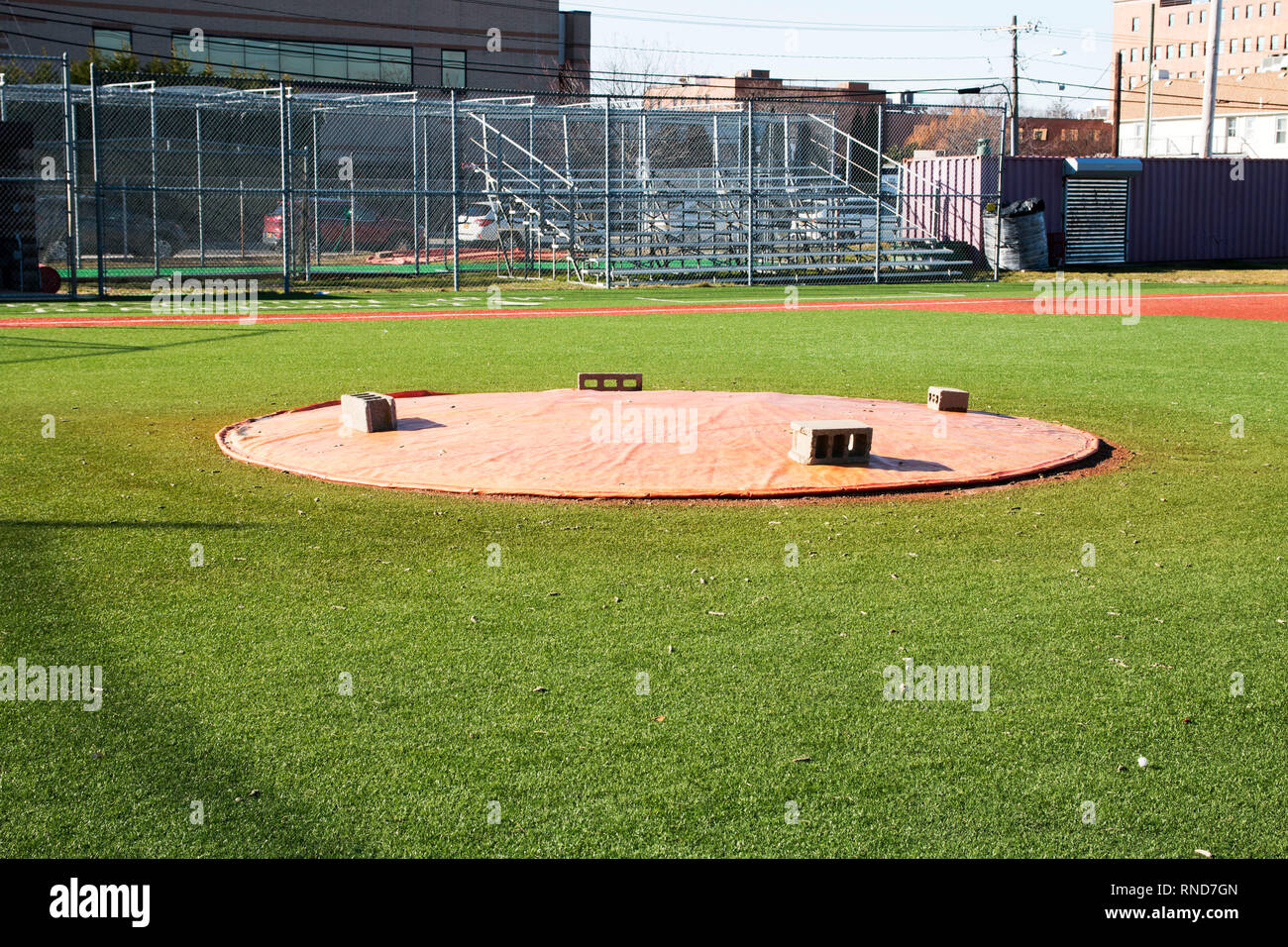 Un baseball pitchers mound è coperto con un telo mantenendolo in buona forma per la giornata di gioco Foto Stock