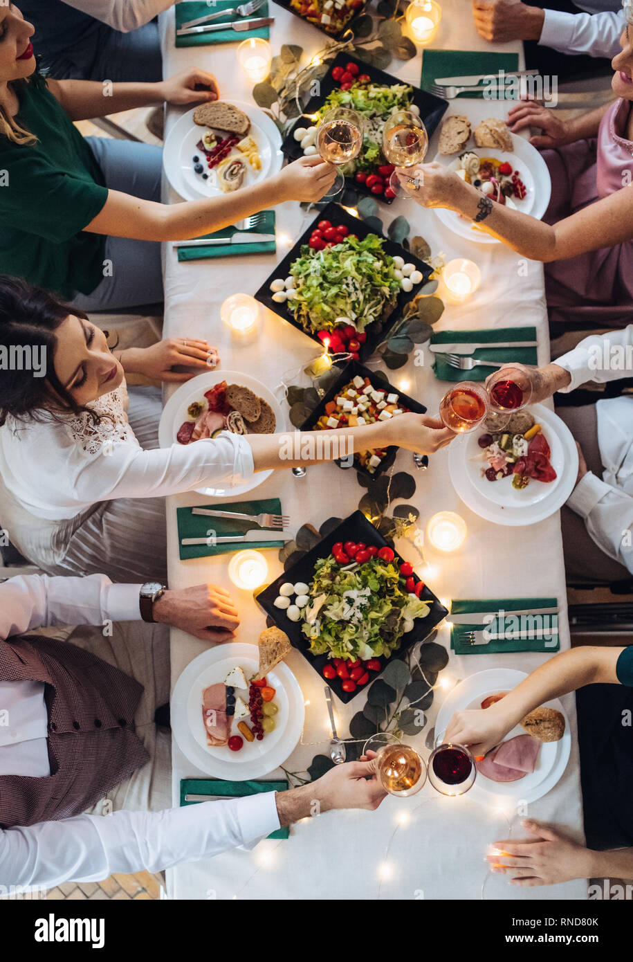 Una vista superiore della grande famiglia seduti a un tavolo in una piscina festa di compleanno, bicchieri tintinnanti. Foto Stock