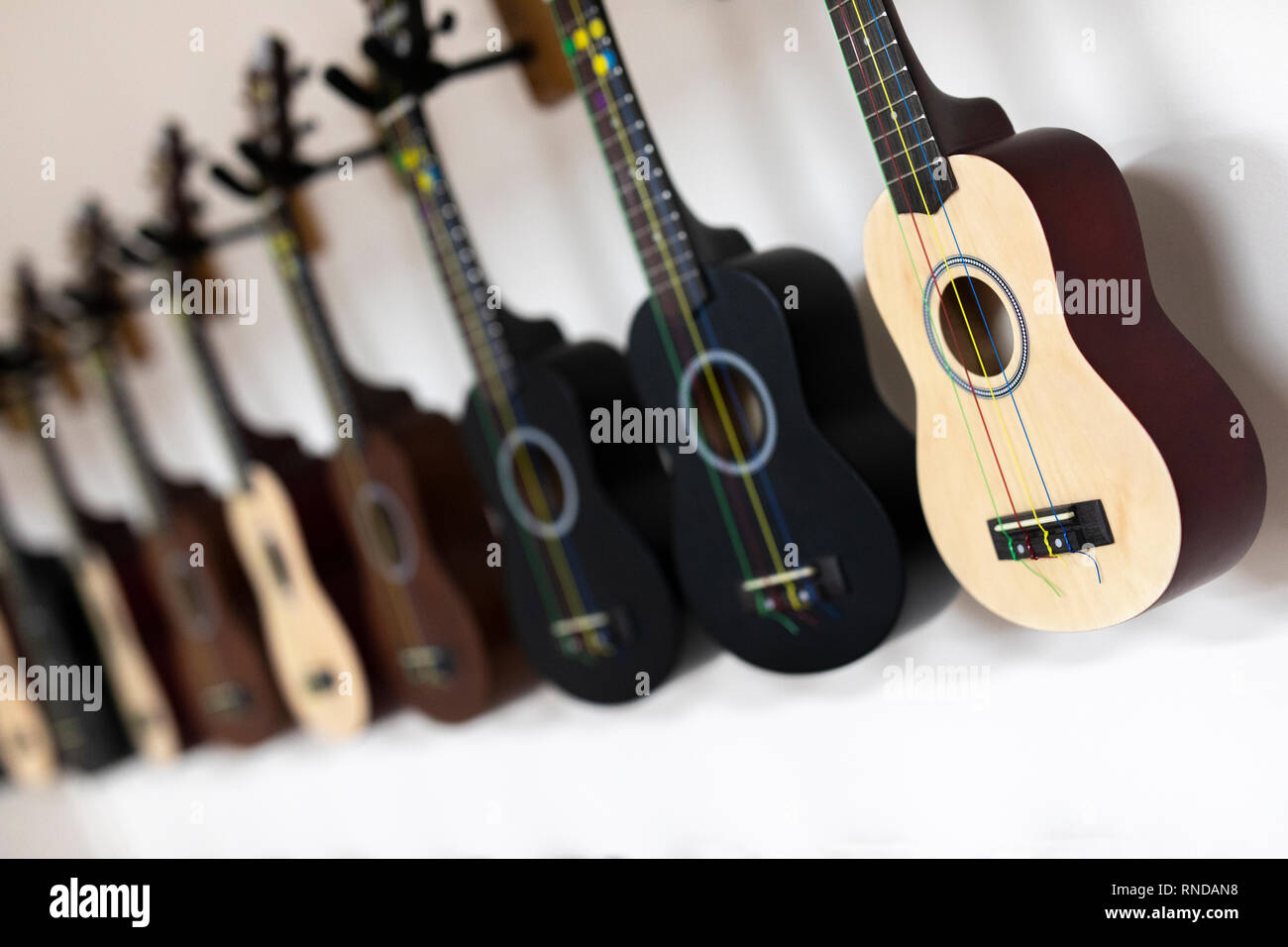 Ukelele appeso alla parete nella scuola sala musica Foto Stock