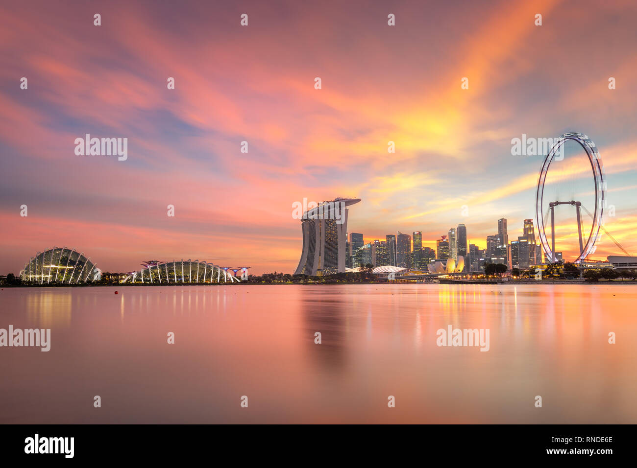 Lo skyline di Singapore con luminarie. Singapore il distretto commerciale, marina bay sabbia e il giardino dalla baia sul tramonto. Foto Stock