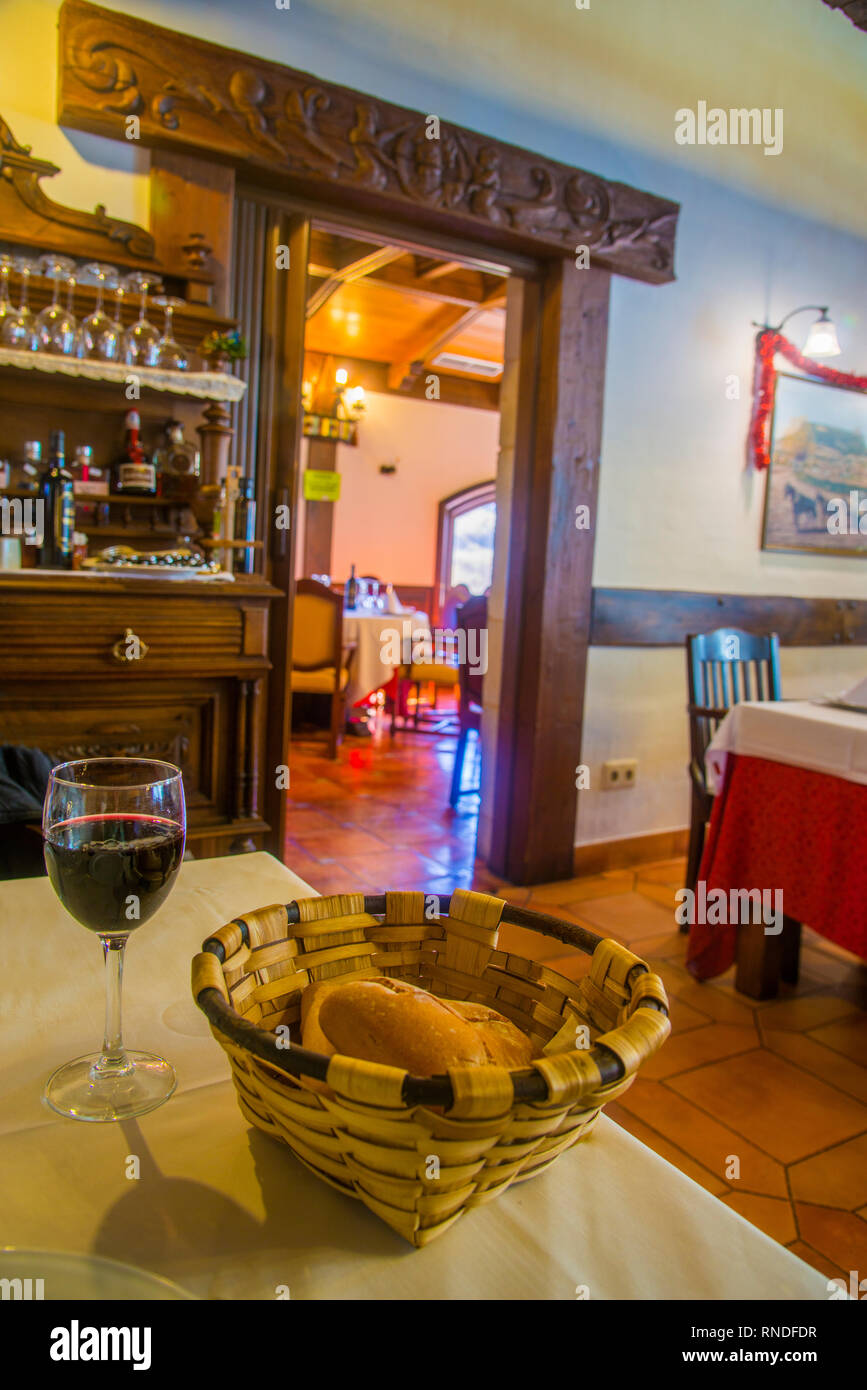 Cestino con pane e un bicchiere di vino in un ristorante tradizionale. Burgos, Spagna. Foto Stock