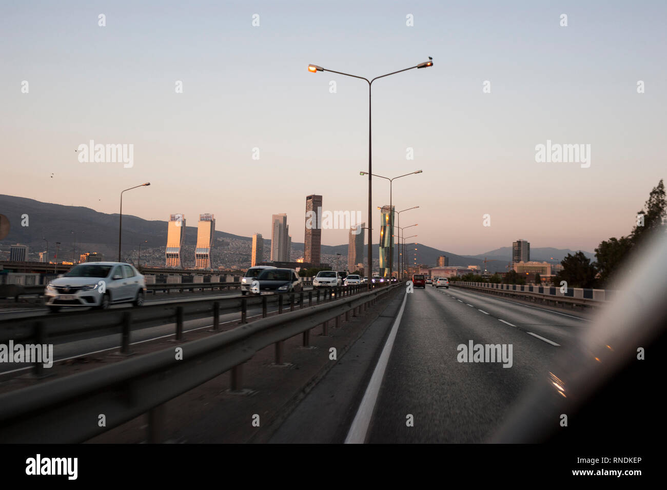 Izmir, Turchia - 3 Agosto 2018: Gee perla skyscrapper, Mistral skyscrapper e torri Folkart vista dalla strada di Ankara con il traffico di Izmir, Turchia. Foto Stock
