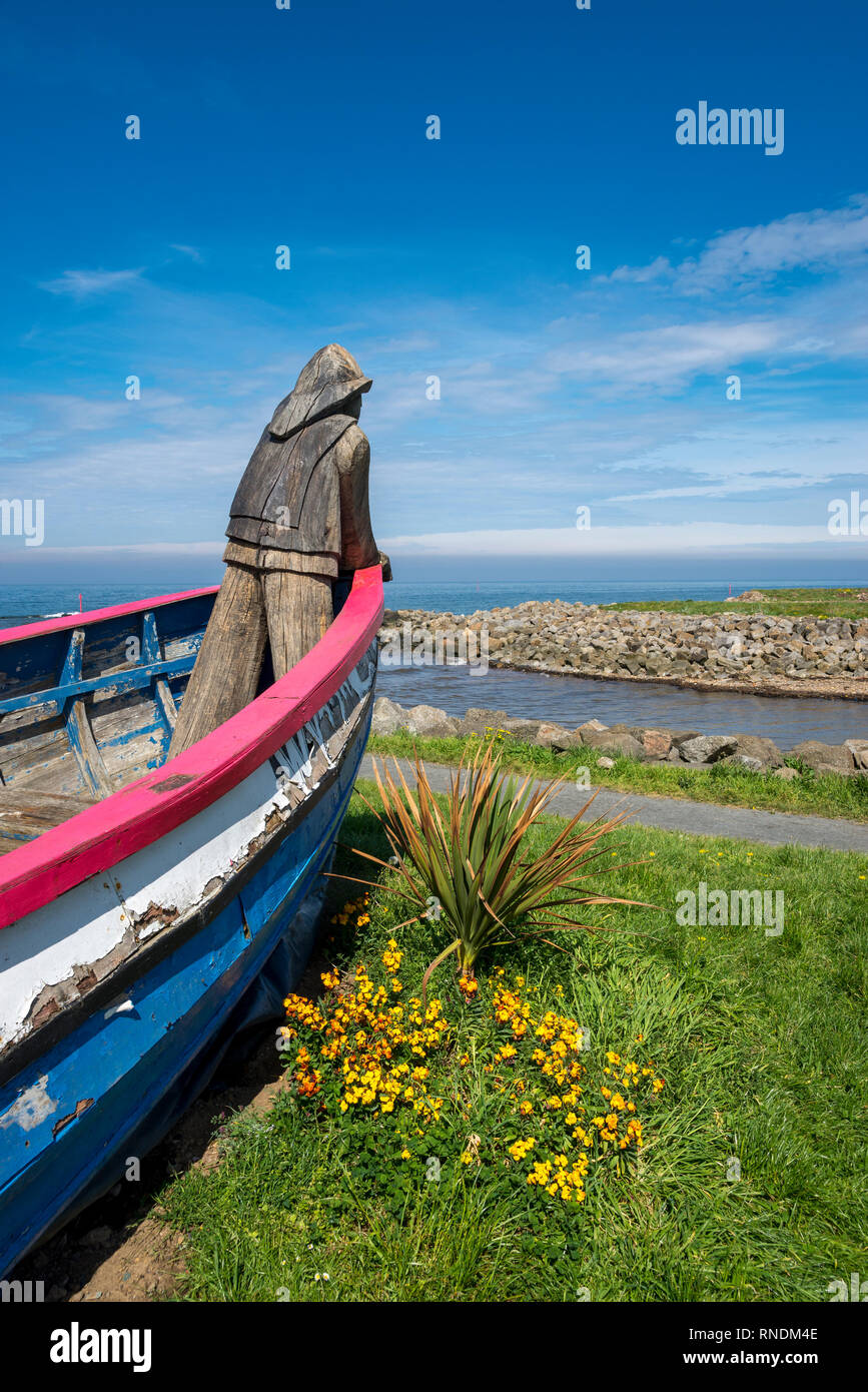 Vecchia barca e scultura in legno dalla spiaggia a Skinningrove sul modo di Cleveland, North Yorkshire, Inghilterra. Foto Stock