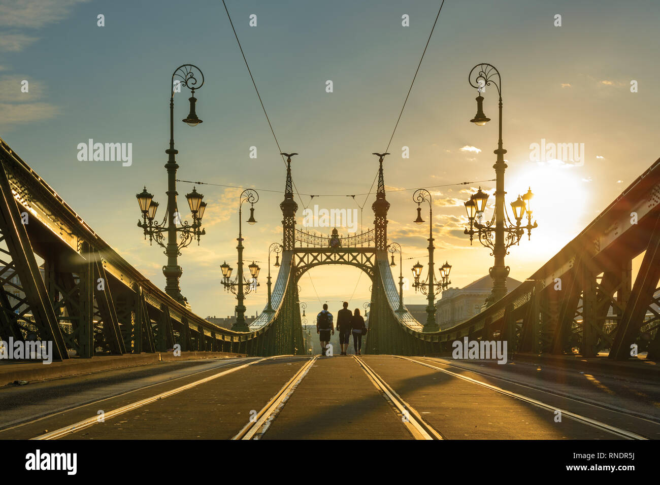 Ponte della Libertà di sunrise, sagome di tre persone a piedi lungo la carreggiata Foto Stock