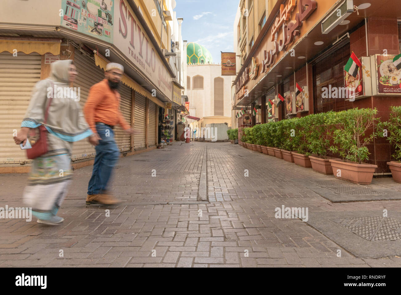 Un pakistano giovane camminando in una strada del e popolare quartiere di Deira in Dubai, United Arab Emirates, Foto Stock