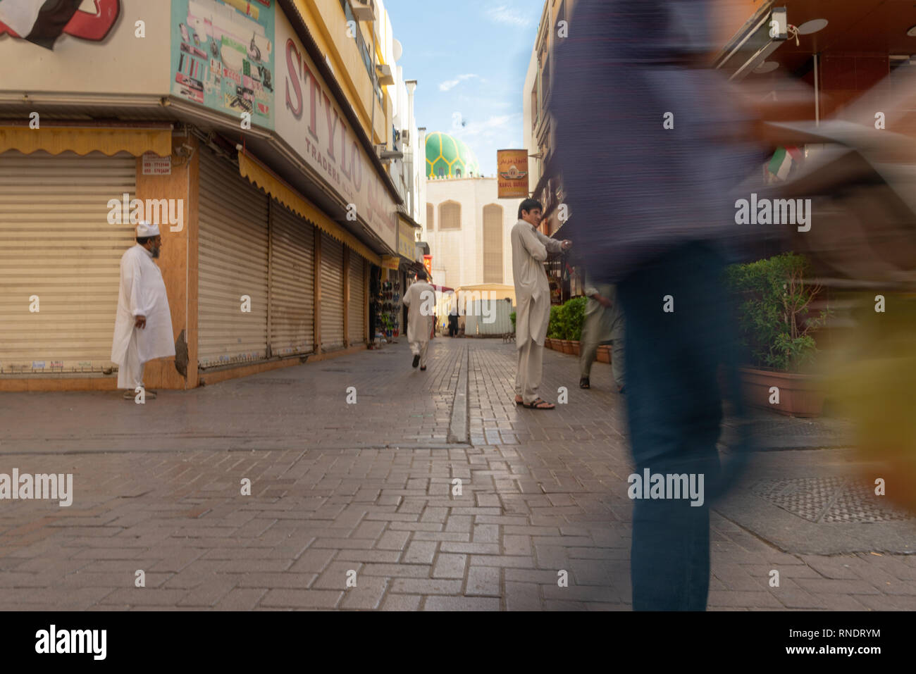 Il pakistan uomini a piedi e in attesa in una strada del e popolare quartiere di Deira in Dubai, United Arab Emirates, Foto Stock