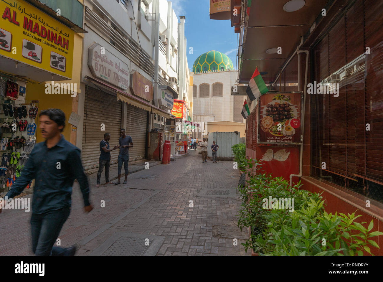 Pakistani e uomini africani Camminare e stare in piedi in una strada del e popolare quartiere di Deira in Dubai, United Arab Emirates, Foto Stock