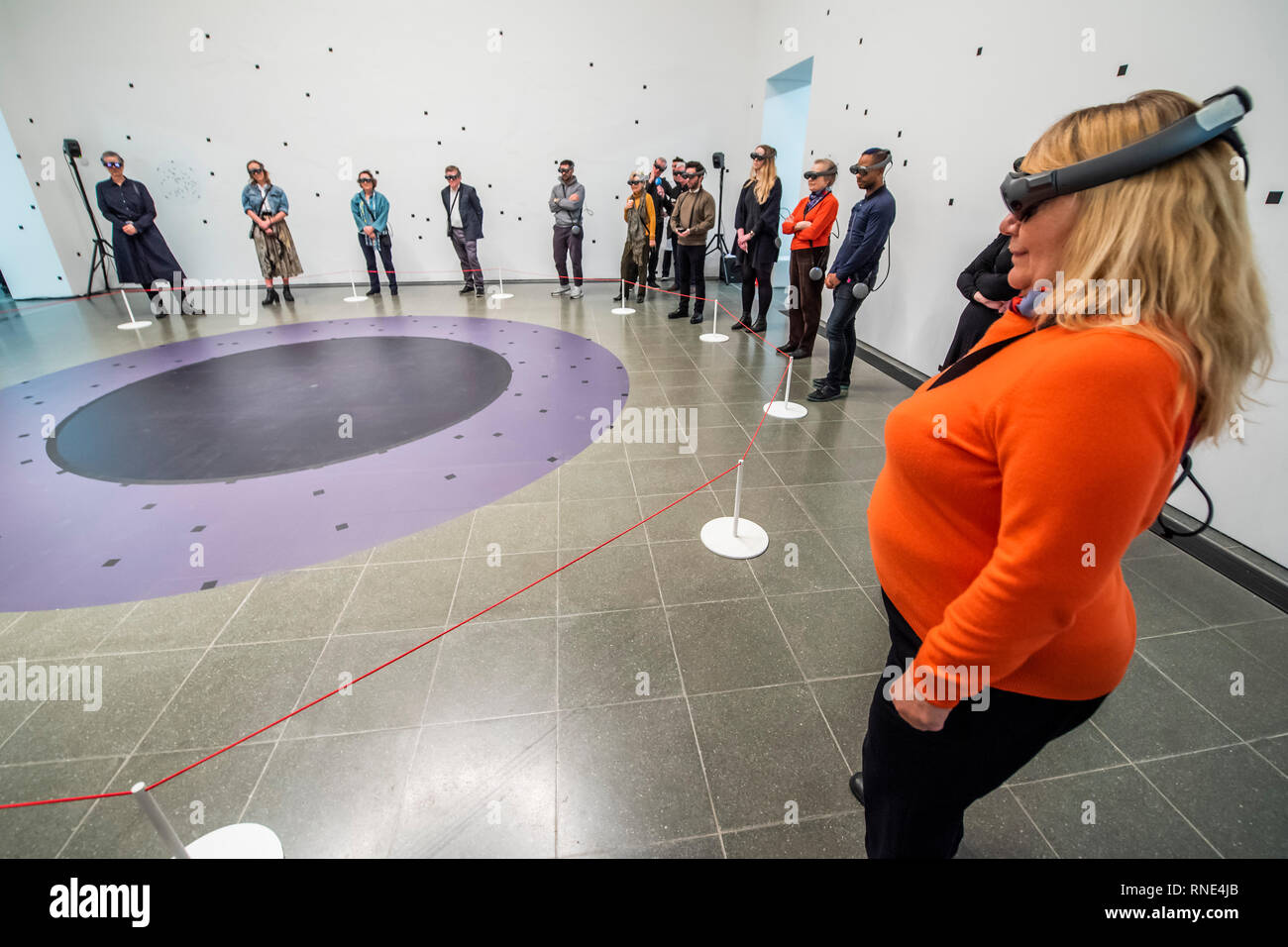 Londra, Regno Unito. 18 Febbraio, 2019. I visitatori sono guidati dai tecnici in camici e guarda l'installazione attraverso gli occhiali di protezione - Marina Abramović, La vita presso la Serpentine Gallery, una perfomance nella realtà mista (un wearable augmented esperienza). Il pezzo, della durata di 19 minuti, si basa sull'artista della lunga fascino con il concetto di assenza di materiale. L'uso della realtà mista Abramović consente di esaminare il modo di usare il proprio corpo come soggetto e oggetto, la mappatura di un territorio nuovo nel punto di intersezione tra la tecnologia e le prestazioni. Credito: Guy Bell/Alamy Live News Foto Stock