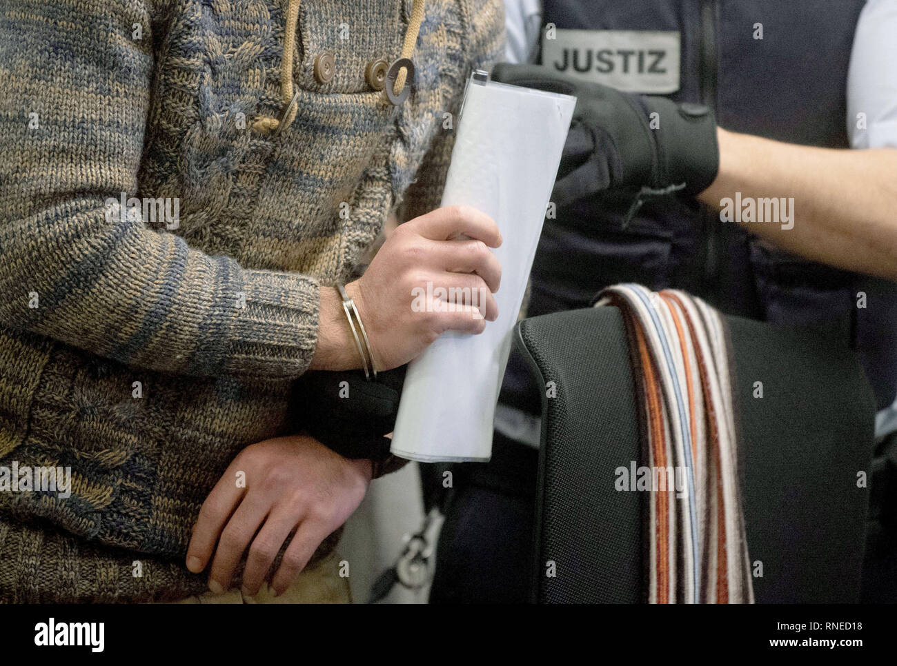 Stuttgart, Germania. 19 Feb, 2019. La parte convenuta (l) nella prova di due presunti crimini di guerra nel conflitto siriano è preso il suo posto in un aula di un tribunale di Stoccarda Alta Corte Regionale. Come membro del 'libero esercito siriano (FSA)','imputato è detto di aver imprigionato e torturato due persone con i compagni di combattenti nella provincia di Idlib. Credito: Marijan Murat/dpa/Alamy Live News Foto Stock
