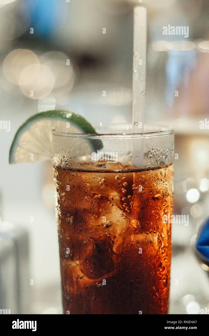 Fino vicino soda drink con ghiaccio e un lime in un bicchiere Foto Stock