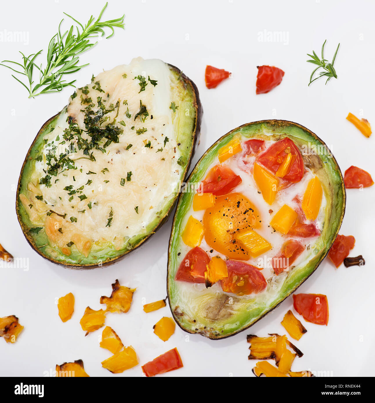 Avocado al forno con uova , formaggio e verdure isolati su sfondo bianco Foto Stock