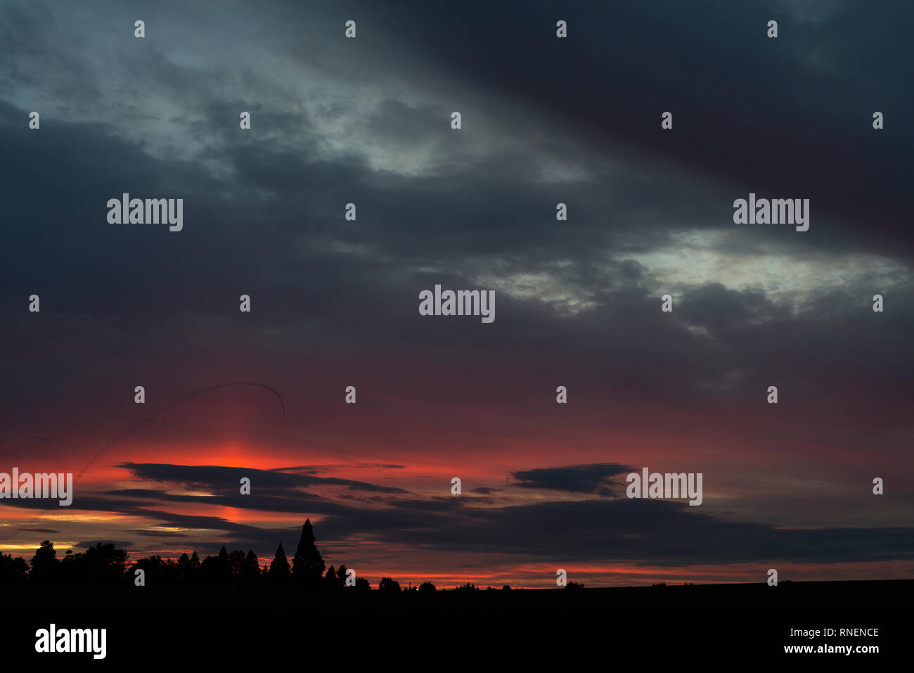 Un tramonto in Oregon con sentieri a getto da un caccia nel cielo. Foto Stock