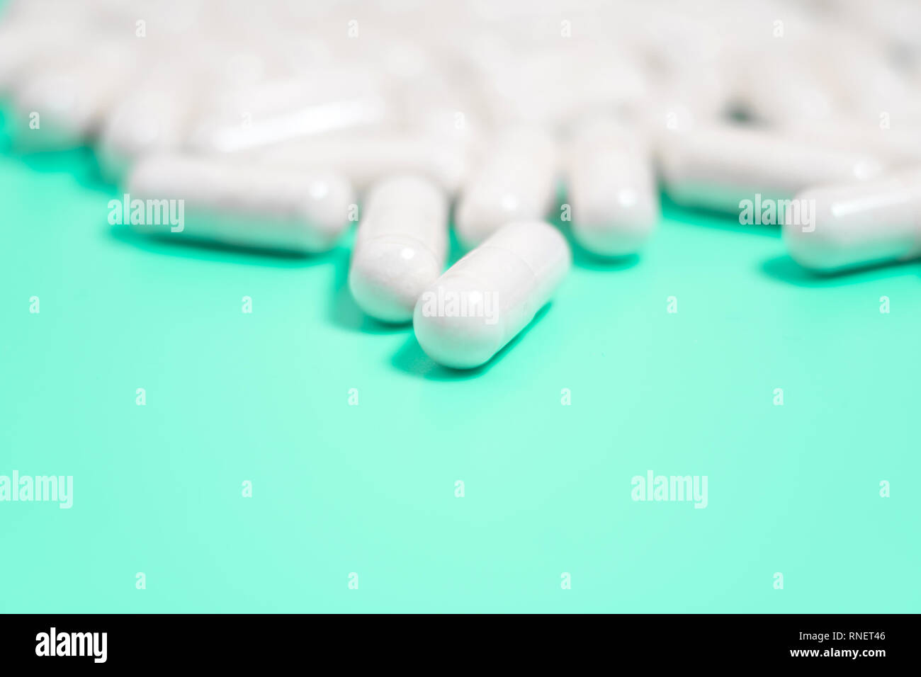 Pillole di bianco su sfondo verde Foto Stock