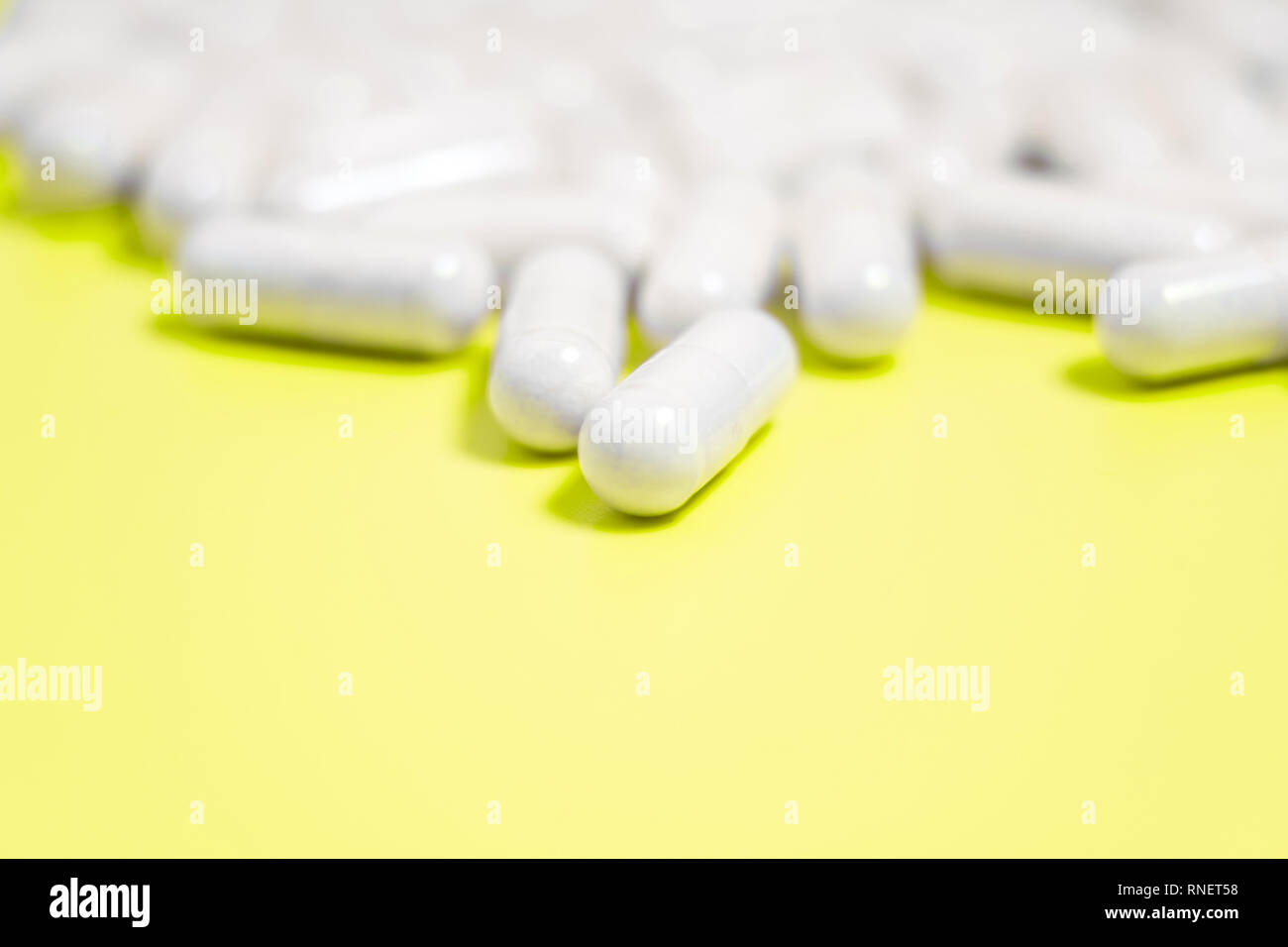 Pillole di bianco su sfondo giallo Foto Stock