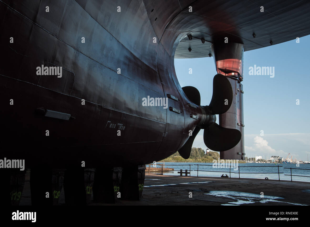 Vista della nave elica e timone in un bacino a secco dello sfondo. Industria dei Trasporti. Il trasporto merci. Per la riparazione navale e il concetto di manutenzione. Foto Stock