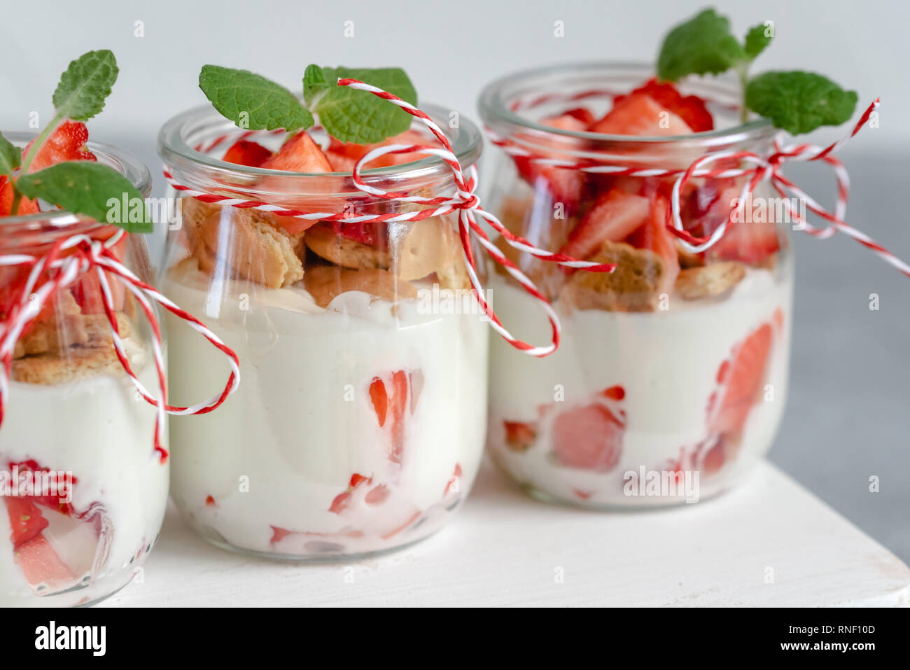 Yogurt con fragole fresche e i biscotti sminuzzati in un vaso. Foto Stock