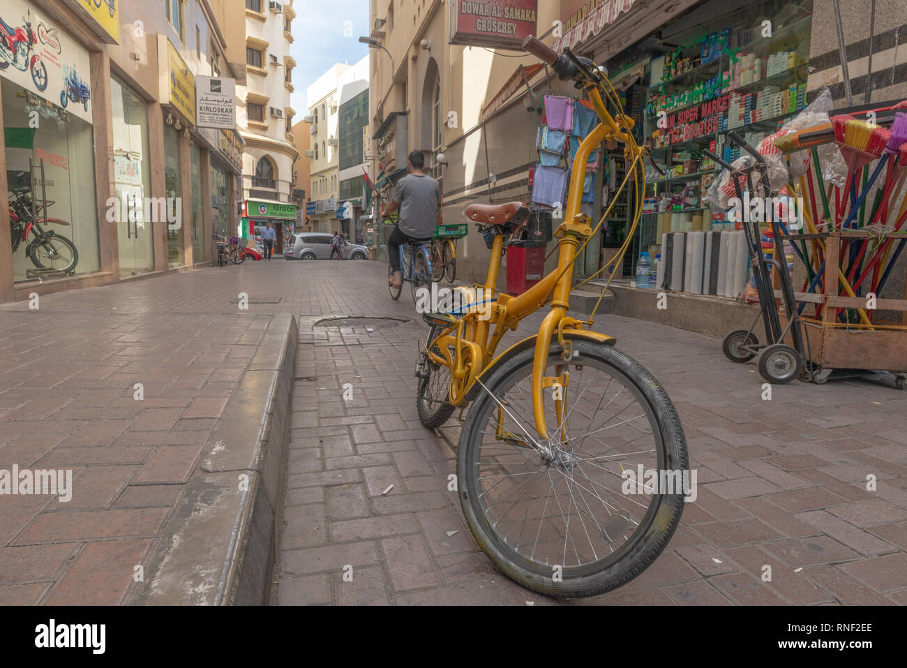 Vecchio e giallo bicicletta in piedi in mezzo alla strada nel popolare etnica e nel distretto di Deira di Dubai, Emirati Arabi Uniti. Foto Stock