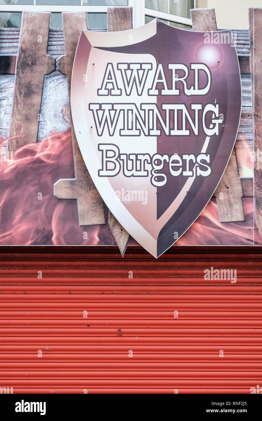 Premiato hamburger firmare al di fuori di una chiusa e parzializzato il fast food ristorante sul lungomare di Rhyl, Denbighshire, il Galles del Nord Foto Stock