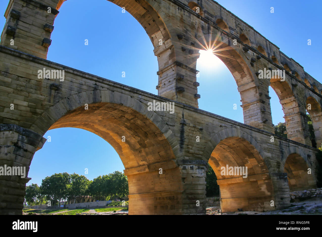 Acquedotto Pont du Gard con sunburst, Francia meridionale. Esso è il più alto di tutti i privilegi elevati acquedotti romani. Foto Stock
