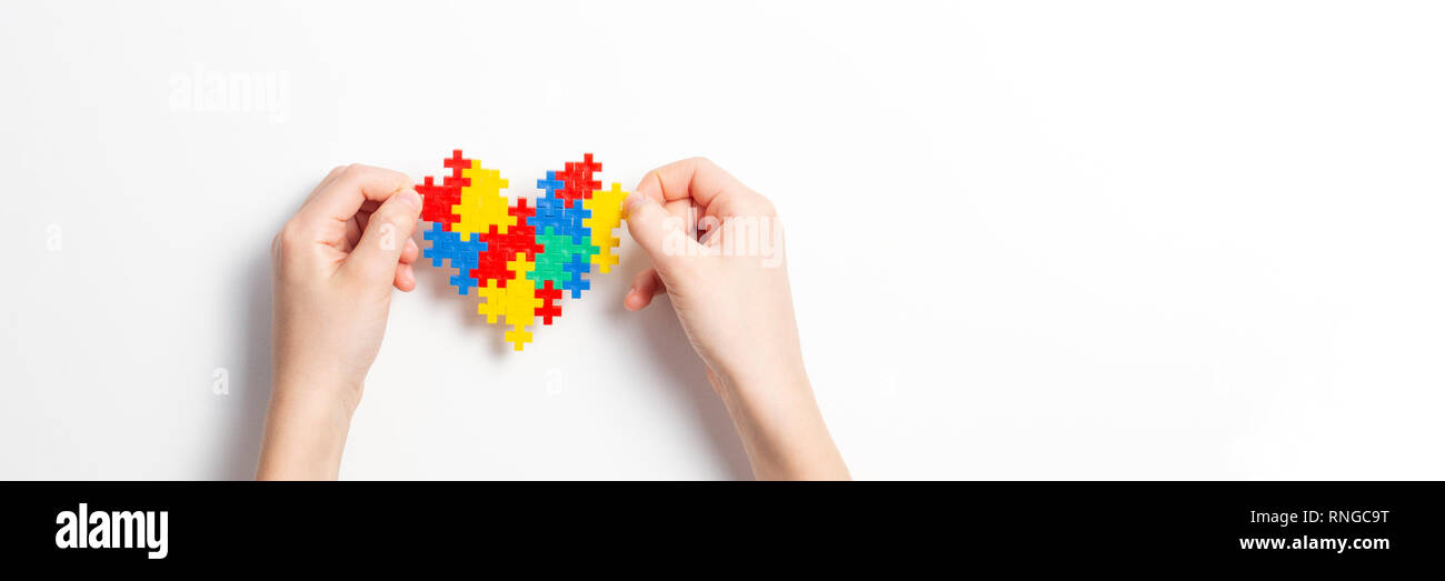 Bambino mani cuore colorato su sfondo bianco. Mondo autismo consapevolezza giorno di concetto Foto Stock