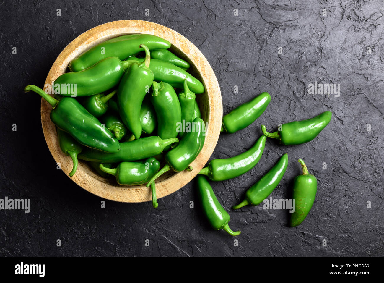 Verde jalapeno hot pepper nel piatto in legno closeup. Fotografia di cibo Foto Stock