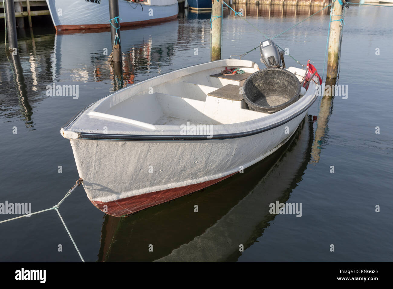 Di piccole dimensioni e di colore bianco in vetroresina barca da pesca con  motore fuoribordo, ormeggiata in porto; Oester Hurup, Danimarca Foto stock  - Alamy