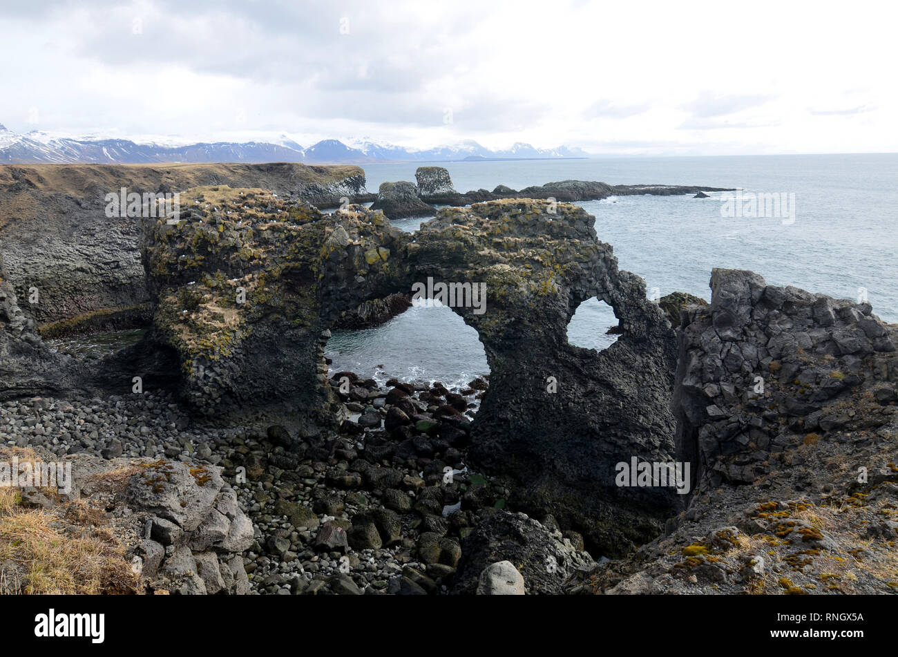 Grande foro di peek e un arco rock si trova sulla costa dell'Islanda. Foto Stock
