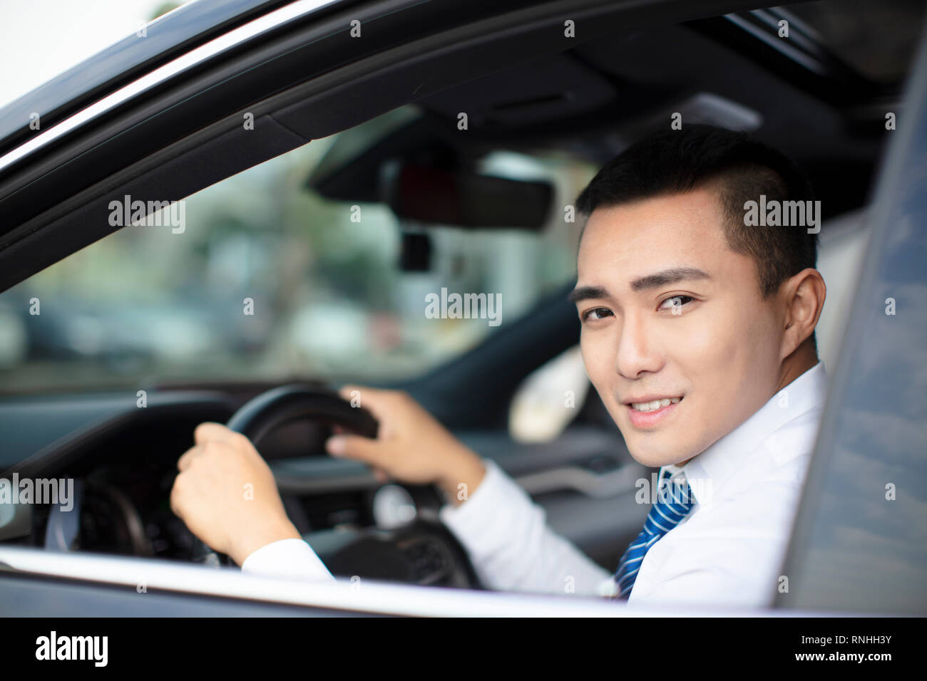 Sorridente azienda giovane uomo alla guida di una vettura Foto Stock